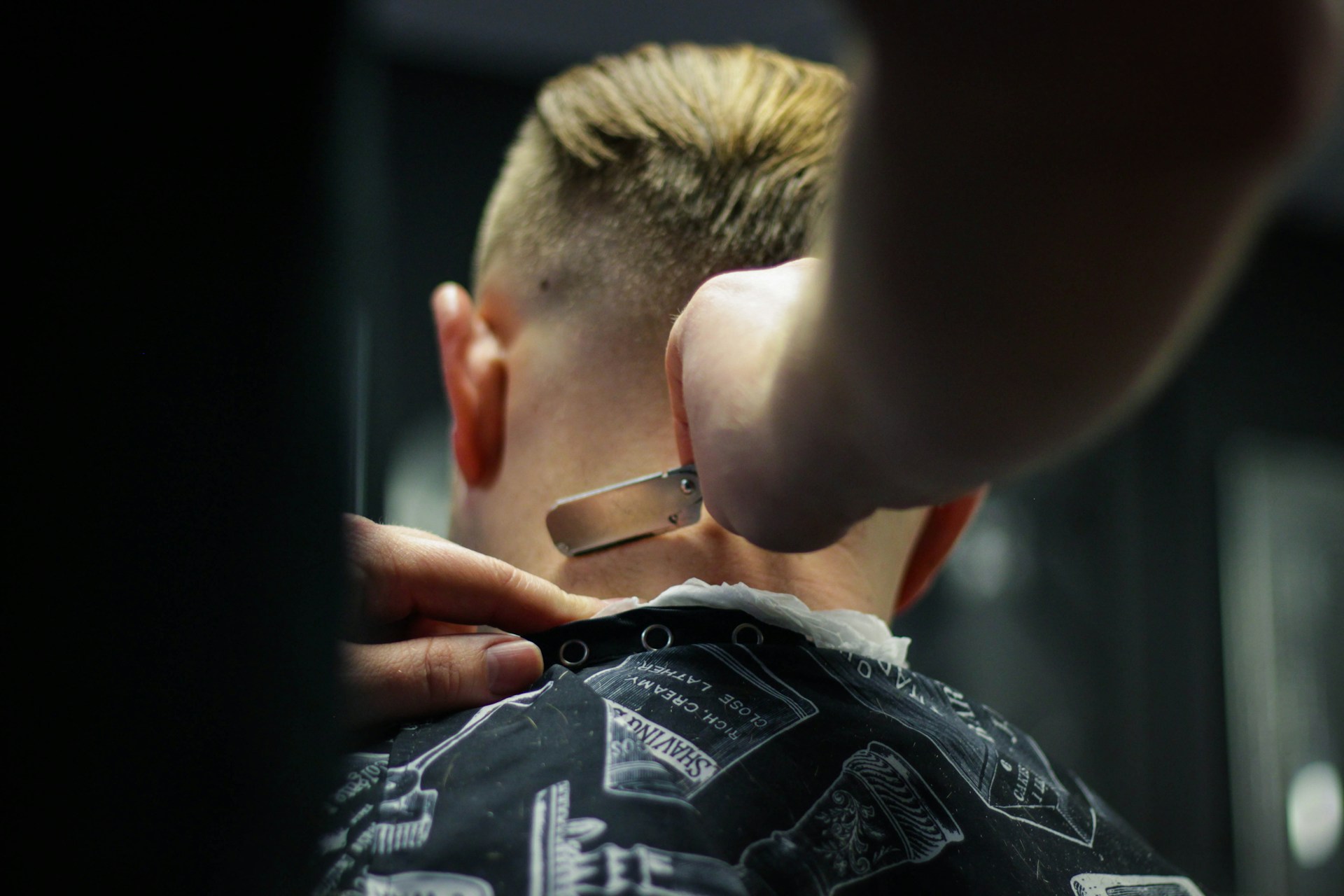 Expert barber trimming hair with precision in Rhode Island